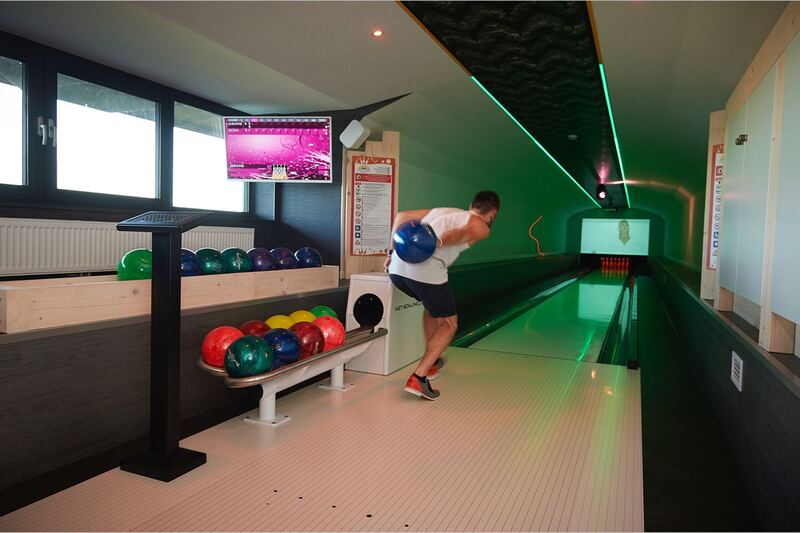 Piste de bowling avec un joueur en plein lancer