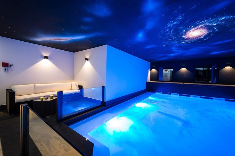 Piscine au bassin éclairé en bleu, avec coin salon